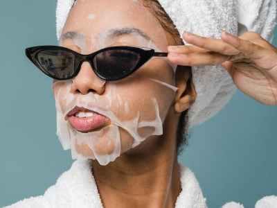 content young black woman wearing sunglasses during skin care treatment after bath